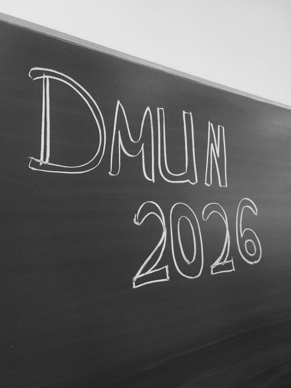 The letters DMUN 2026 written in chalk on a blackboard.